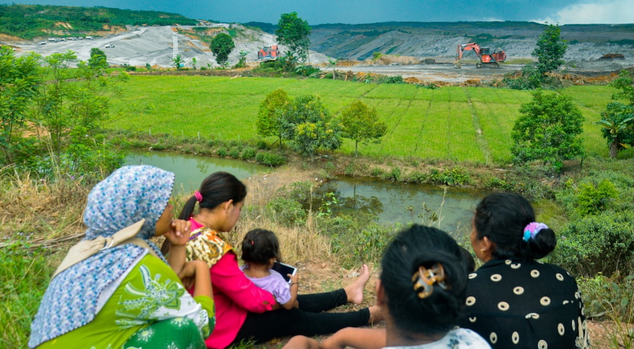 Ibu-ibu di Desa Mulawarman, Kutai Kartanegara, Kalimantan Timur tampak sedang melihat kegiatan tambang yang persis bersebelahan dengan sawah dan pemukiman mereka (Foto: JATAM Kaltim)